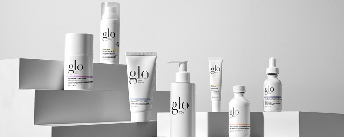 Assorted glo products on white steps including Charcoal Detox Mask, Bio-Renew EGF Cream.