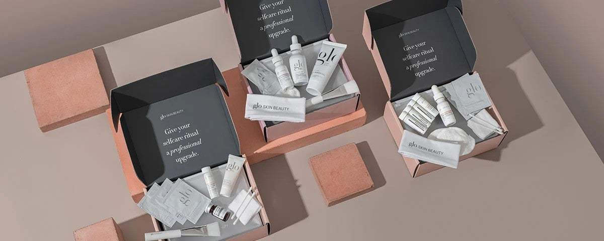 Glo Skin Beauty kits with products; lid text: 'Give your selfcare ritual a professional upgrade.' 'glo SKIN BEAUTY' visible.