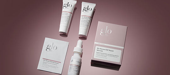 glo skincare products: two tubes, a dropper bottle, sachet and boxed product arranged on a pink background
