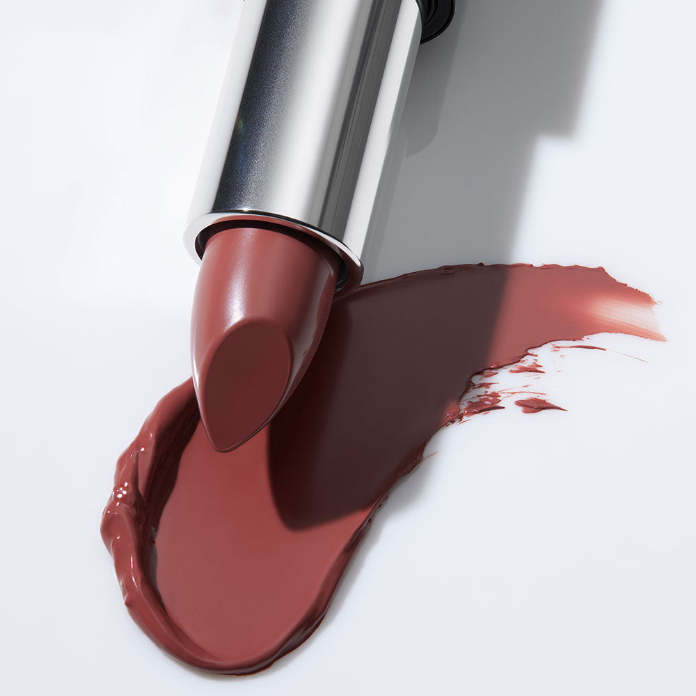 Rose-brown satin lipstick bullet with matching smeared swatch on white background