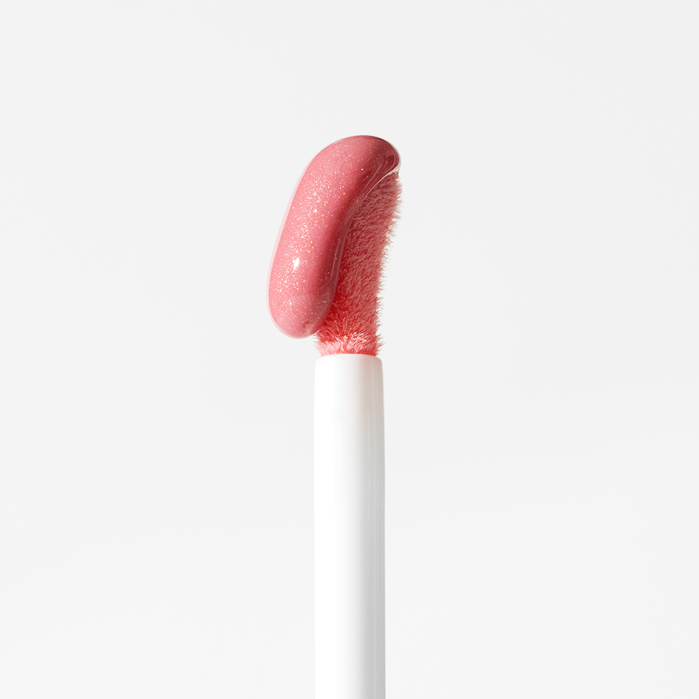 Angled fuzzy applicator holding pink sparkly lip-gloss swatch