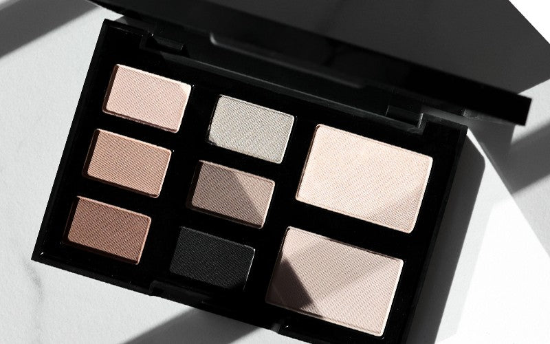 Neutral nine-pan eyeshadow palette in black compact, shades ranging from light beige to deep black