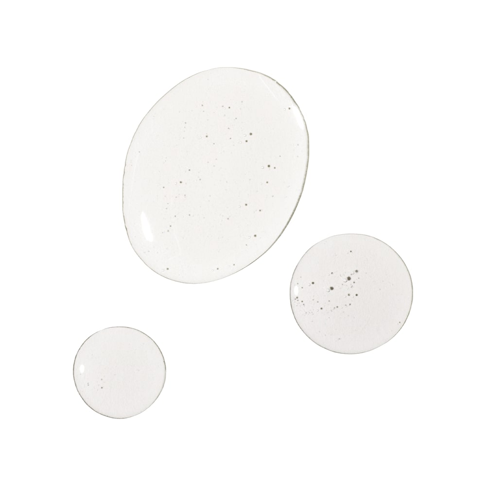 Three translucent oil droplets with tiny air bubbles on a white background