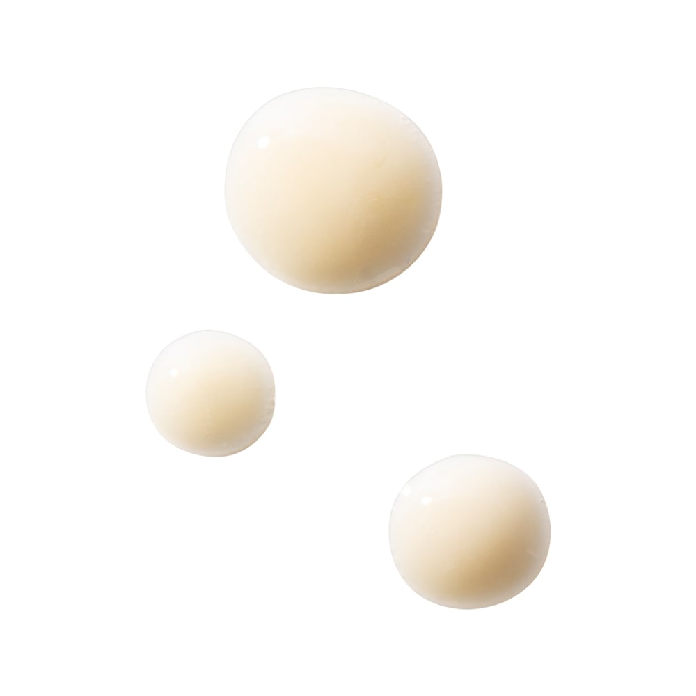 Three creamy pale-beige serum droplets on a white background