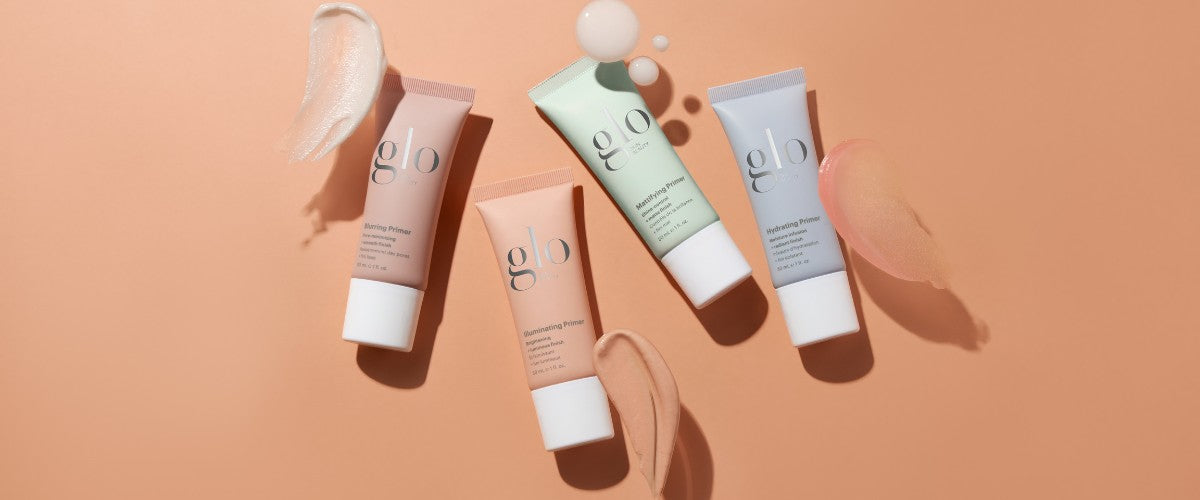 Four glo primers — Blurring Primer, Illuminating Primer, Mattifying Primer, Hydrating Primer — tubes and swatches on a peach background.