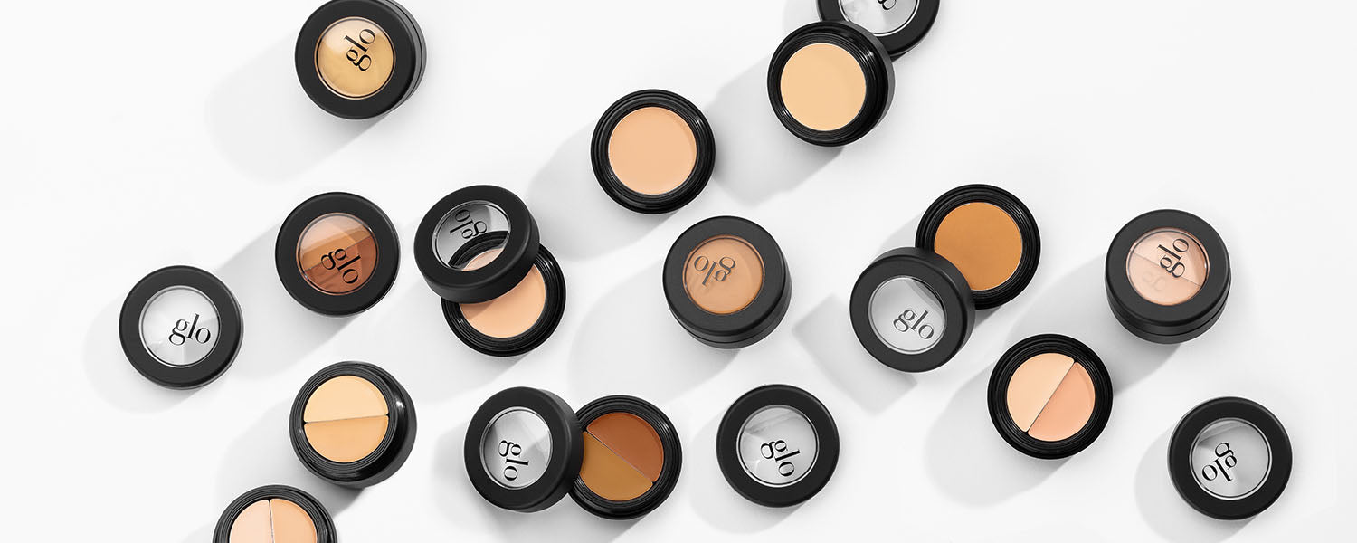 Open and closed glo concealer pots on white background, showing various skin-tone shades and glo logos