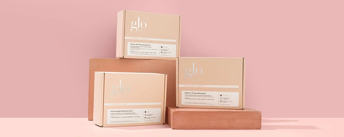 Three pink-beige boxes labeled 'glo' stacked against a pink background