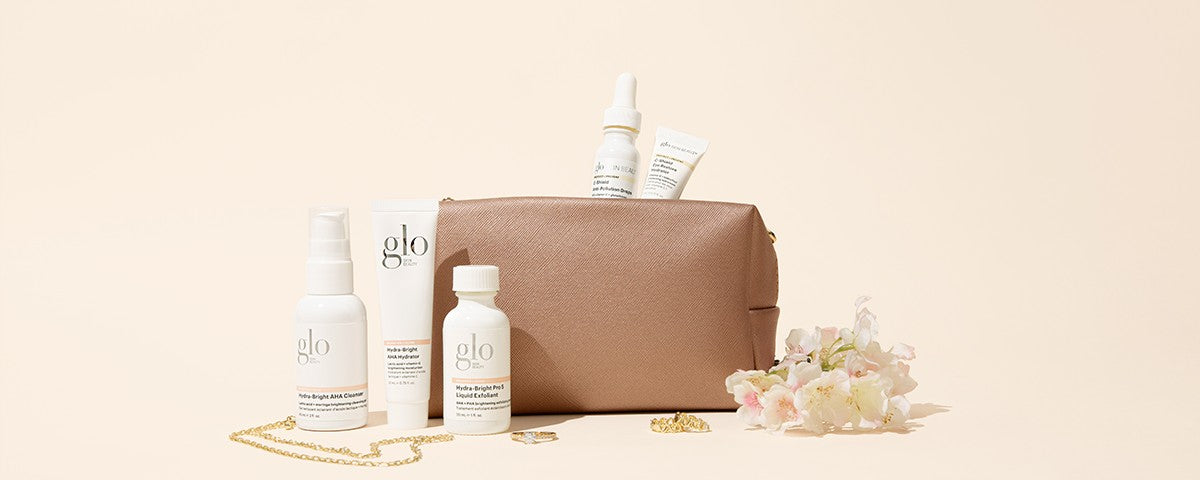 glo skin beauty bottles and pouch: Hydra-Bright AHA Cleanser, Hydra-Bright AHA Hydrator, Hydra-Bright Pro-S Liquid Exfoliant