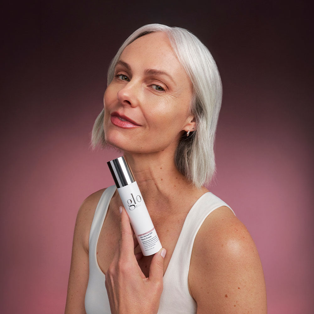 Front view of Bio-Renew EGF Neck Cream bottle with pump held to a model’s neck on pink gradient background