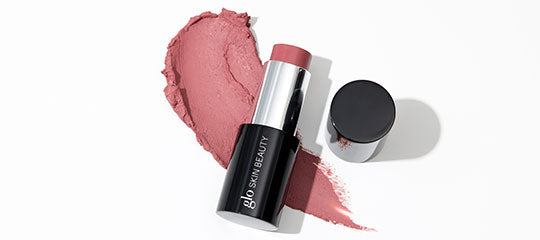 Mauve lipstick tube and cap on a matching smeared swatch; tube labeled glo SKIN BEAUTY