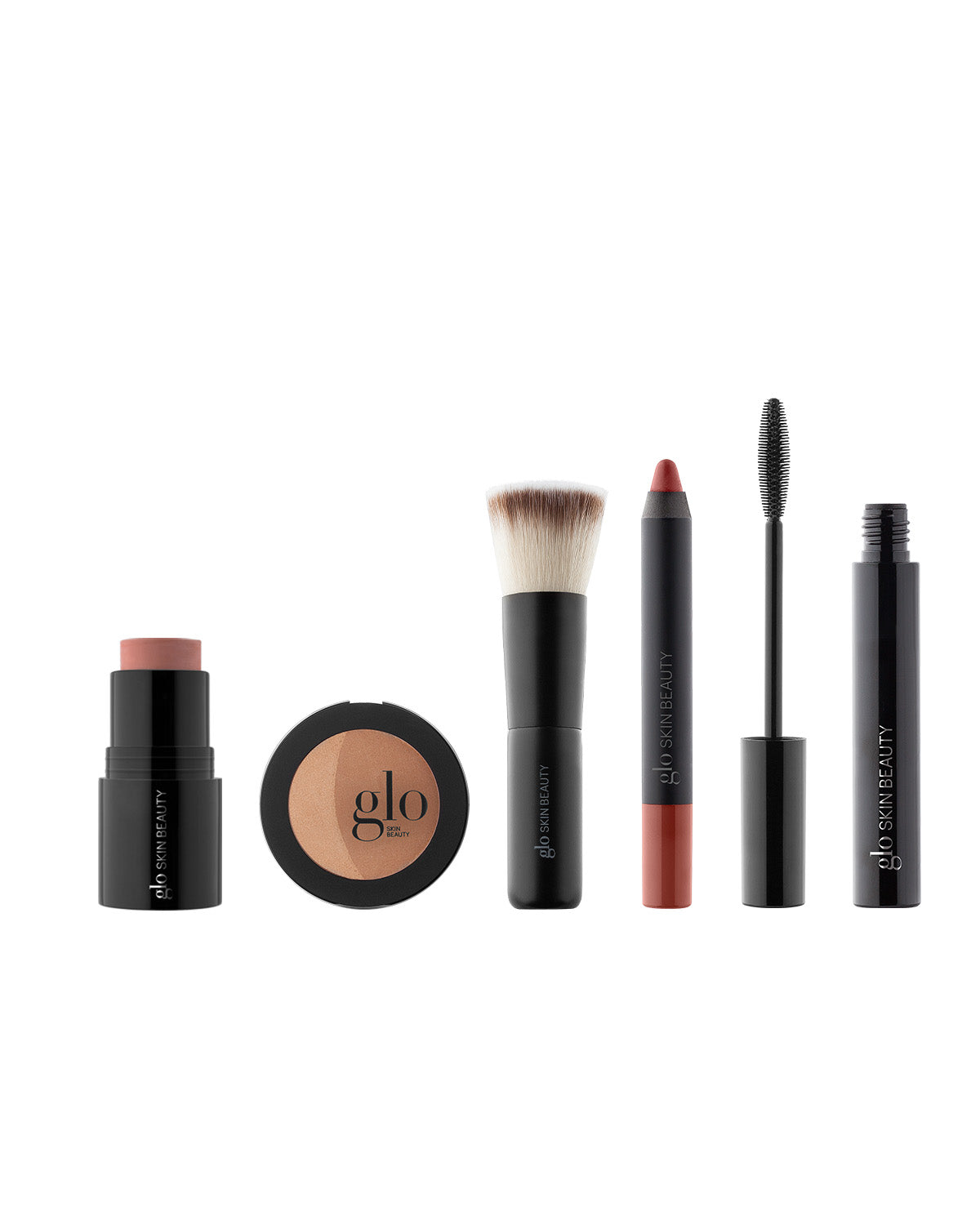 Front view of 5-piece makeup kit: cream stick blush, bronzer compact, kabuki brush, rosy lip crayon, open mascara on white