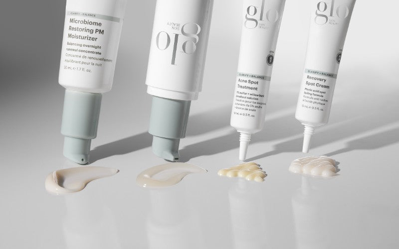 Four acne-treatment tubes at top with dollops of their creams below, showing packaging, labels, and textures.