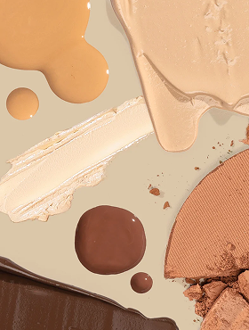 Makeup swatches: foundation strokes, brown cream drops, broken pressed powder and chocolate smear on beige surface.