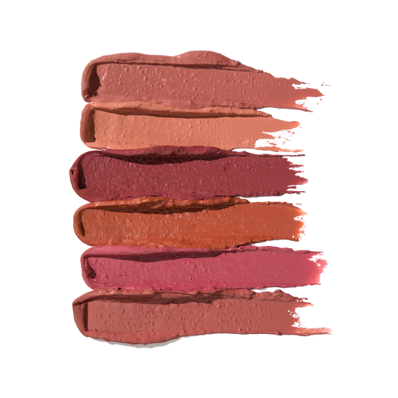 Six horizontal creamy lip-crayon swatches in warm nudes, pink, rose and terracotta on white background.