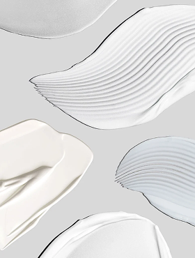 Abstract cream and lotion swatches in neutral tones on a light gray background
