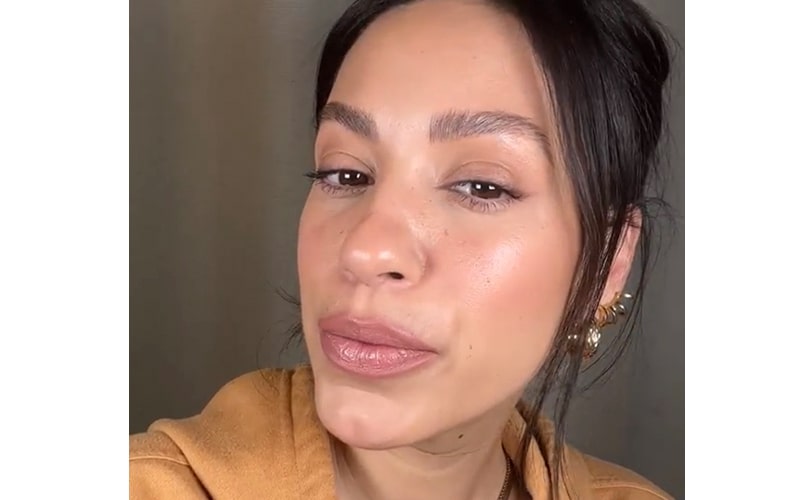 Close-up of woman wearing nude lipstick and natural makeup, head slightly tilted