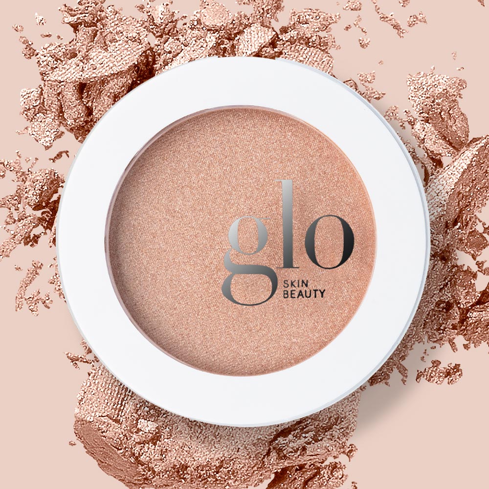 Baked highlighter compact in peach-champagne tone, white case with 'glo SKIN BEAUTY' logo.