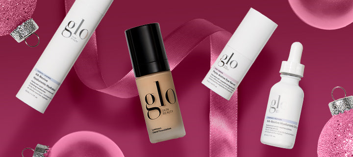 glo Skin Beauty foundation and skincare bottles with pink ribbon and glitter ornaments on magenta background